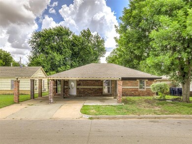 Ranch-style house featuring concrete driveway, a front yard, brick siding, and a carport