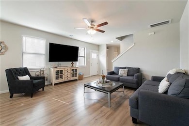 Living room featuring baseboards, a ceiling fan, 