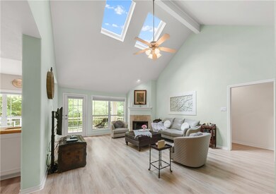 Living room with high vaulted ceiling, a skylight,