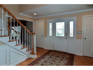 Entry/Foyer. The lovely two story hardwood entry boasts hardwood floors, a beautiful turned staircase, judges paneling, recessed lighting, a large chandelier and oversized window.