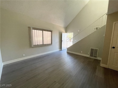 Spare room with a textured ceiling, dark wood-styl