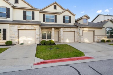 Multi unit property with stone siding, driveway, and stucco siding