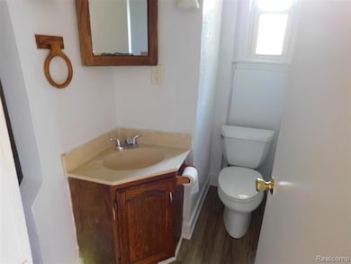 Half bathroom with vanity and dark wood-style flooring