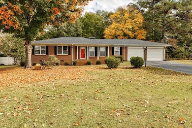 Single story home featuring a front lawn, a garage
