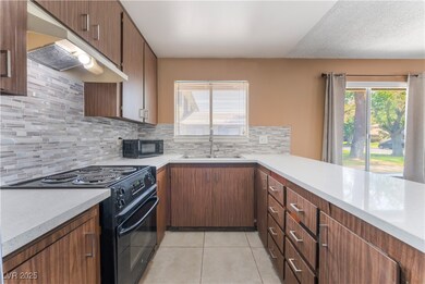 Kitchen with black appliances, a sink, and light c
