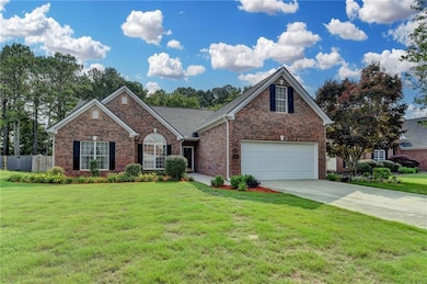 View of front of house with driveway, brick siding, and an attached garage