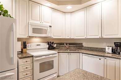 Kitchen featuring white cabinets, white appliances