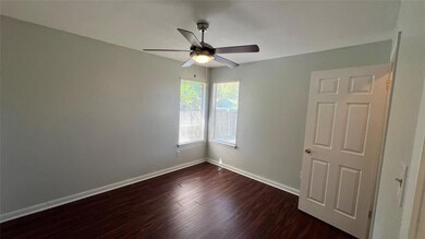 Unfurnished room featuring ceiling fan, dark wood
