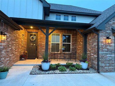 View of exterior entry with brick siding, a shingled roof, a porch, and board and batten siding
