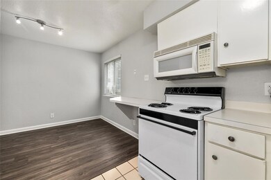 Kitchen with light countertops, white cabinets, w