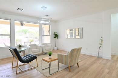 Living area with crown molding, light wood-style f