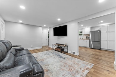 View of the flow to the kitchen with white cabinetry and wood look LVP flooring