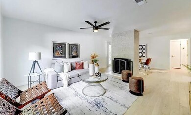 Living area with wood finished floors, a tile fireplace, and a ceiling fan