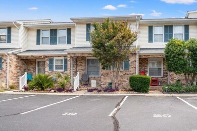Townhome / multi-family property with uncovered parking and brick siding