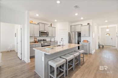Kitchen with a sink, visible vents, appliances with stainless steel finishes, and gray cabinetry