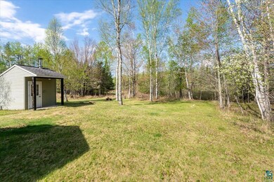 View of green lawn featuring an outbuilding