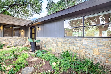 Entrance to property featuring stone siding