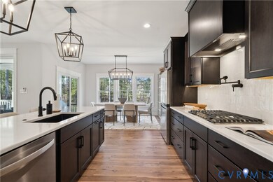 Kitchen featuring stainless steel appliances, light countertops, light wood-style flooring, recessed lighting, and wall chimney range hood