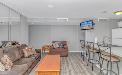 Living area featuring light wood-style floors and baseboards