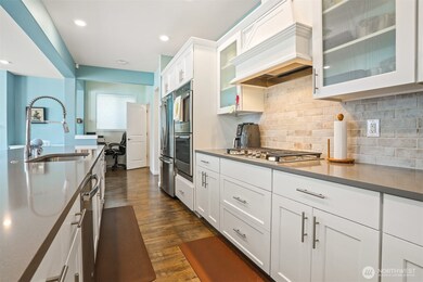 Gourmet kitchen with gas cooktop, double wall oven, french door refrigerator, stainless appliances, slab quartz countertops, center island eating bar that opens to the great room (living and dining rooms).