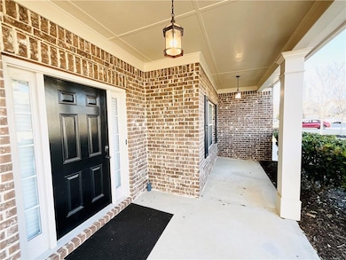 Entrance to property with brick siding and covered