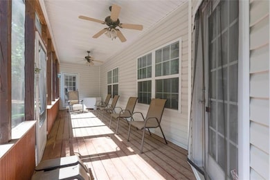 Sunroom featuring a ceiling fan and hardwood / wood-style flooring