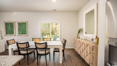 Dining area with dark wood finished floors, baseboards, and visible vents