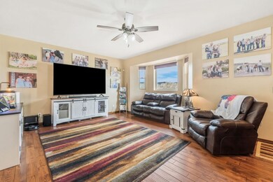 Living area featuring ceiling fan and hardwood / w