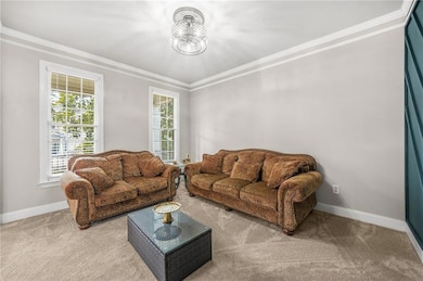 Carpeted living area with a chandelier, crown mold