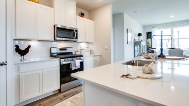 Kitchen featuring white cabinetry, decorative back