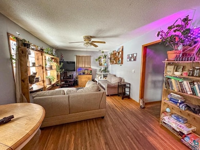 Living area with a ceiling fan, a textured ceiling
