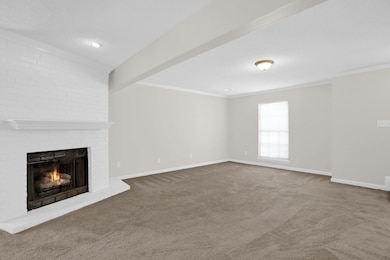 Unfurnished living room featuring a fireplace, carpet floors, and ornamental molding