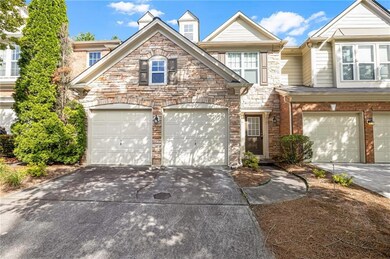 View of front of house with concrete driveway, an attached garage, and stone siding