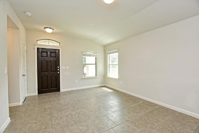 Foyer featuring vaulted ceiling and tile patterne