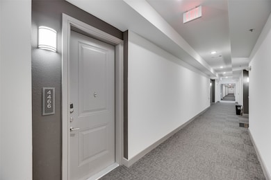 Hall with light carpet and recessed lighting