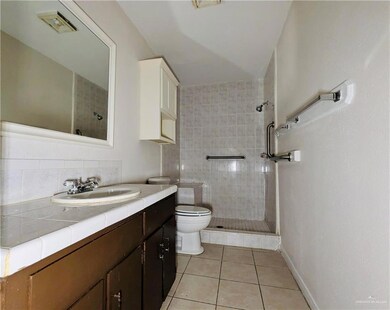 Full bath featuring tile patterned floors, tiled shower, toilet, and decorative backsplash