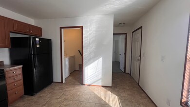 Kitchen featuring black appliances, washing machine and clothes dryer, and light tile patterned floors