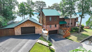 Chalet / cabin featuring brick siding, driveway, metal roof, and a garage