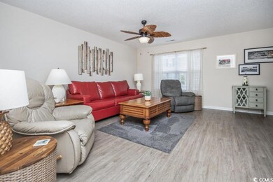 Living area with wood finished floors, ceiling fan