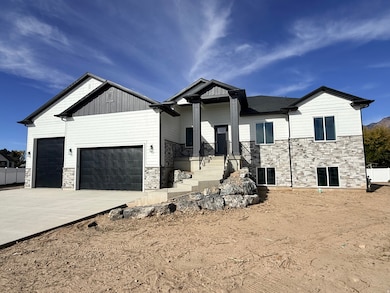 View of front of house featuring stone siding, a garage, concrete driveway, and board and batten siding