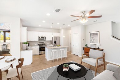Living area with ceiling fan, light wood-style fl