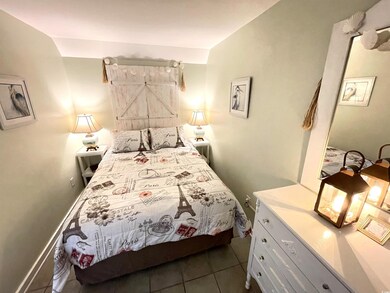 Bedroom with a barn door and dark tile patterned f