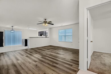 Unfurnished living room featuring ceiling fan and carpet floors