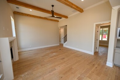 Unfurnished living room with a ceiling fan, beamed ceiling, light wood-type flooring, recessed lighting, and a fireplace