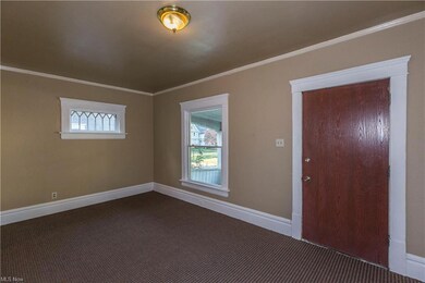 Carpeted spare room featuring crown molding