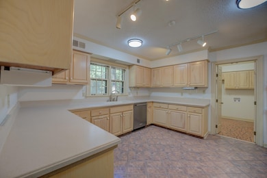 Kitchen featuring dishwasher, light brown cabinetr