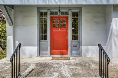 Original front wood door surrounded by transom windows.