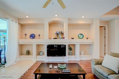 Living room with built in shelves, ceiling fan, an
