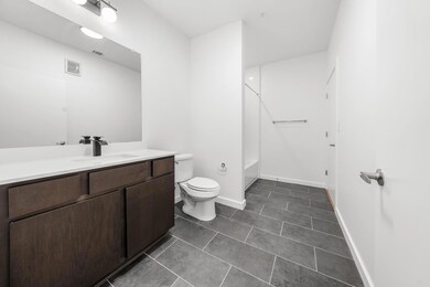 Bathroom with visible vents, toilet, washtub / shower combination, tile patterned flooring, and vanity