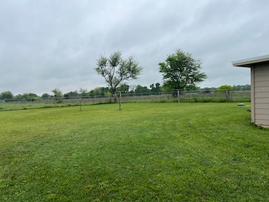 View of yard with fence and a rural view